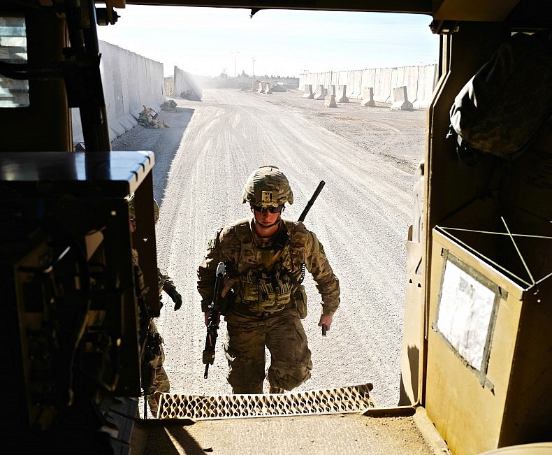 A soldier of the U.S. infantry platoon providing security for the NATO advisors entering a Mine-Resistant Ambush Protected (MRAP) vehicle. Photo by Franz-Stefan Gady.