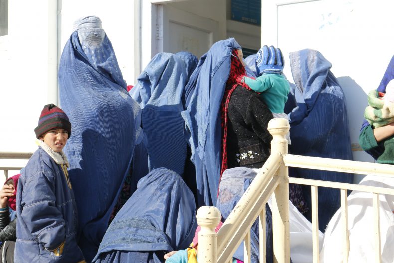Afghan women wait outside a Basic Package of Health Services (BPHS) Clinic to seek maternal health advise where the midwife would also notice the bruises on their body parts. Image by Ritu Mahendru.