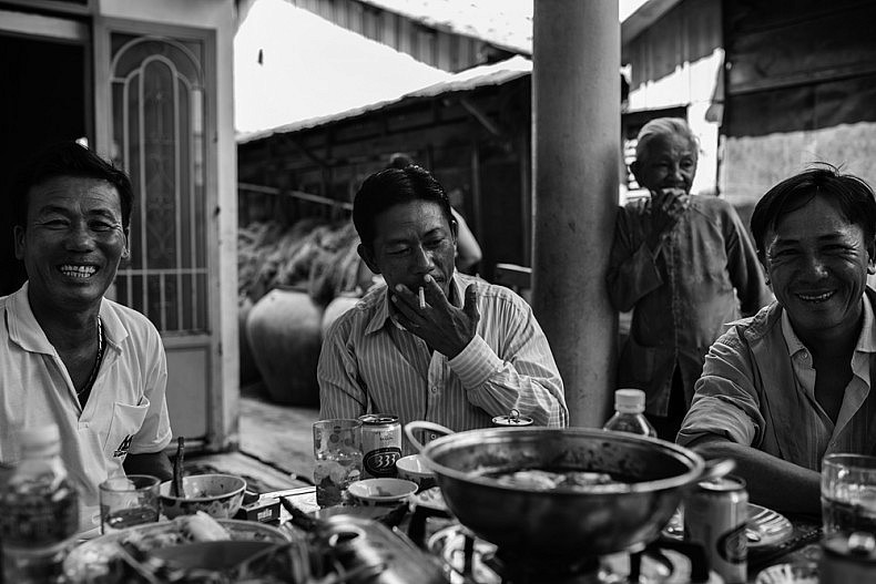 The Nguyen family enjoying a fresh seafood meal after a hard mornings work hauling shrimp in the South China Sea. Photo by Gareth Bright.