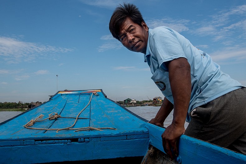 Horm Sok, a researcher for Conservation International, drags a boat over a shallow sandbar on his way to an area of forest he is responsible for monitoring. Photo by Luc Forsyth.