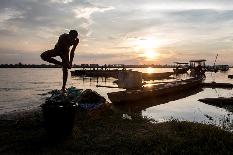 A man washes his feet along the banks of the  Mekong river in the town of Nakasang. Photo by Luc Forsyth.