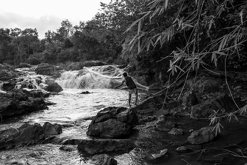 A man casts his fishing net into a pool of water above the Khone Phapheng waterfalls. Photo by Gareth Bright.