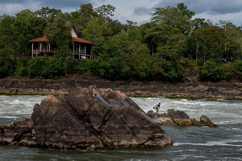 A fisherman casts his net into the turbulent water below the  Khone Phapheng waterfalls. Photo by Luc Forsyth.