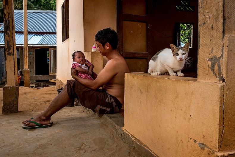 A man with his newborn baby in the village of Khoc Kham. Photo by Luc Forsyth.