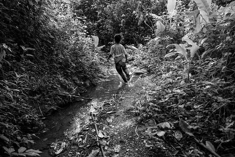 A boy runs down a path outside the village of Khoc Kham. Photo by Gareth Bright.