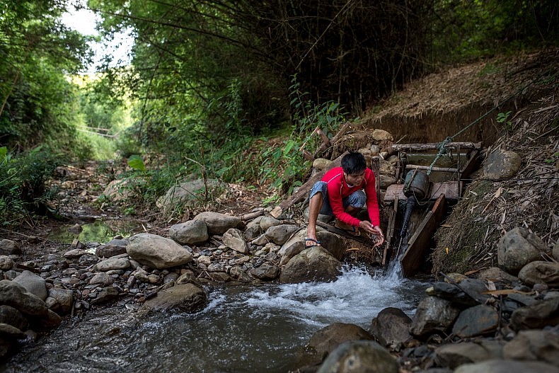 A man checks on his families water turbine in the village of Khoc Kham. Photo by Luc Forsyth.