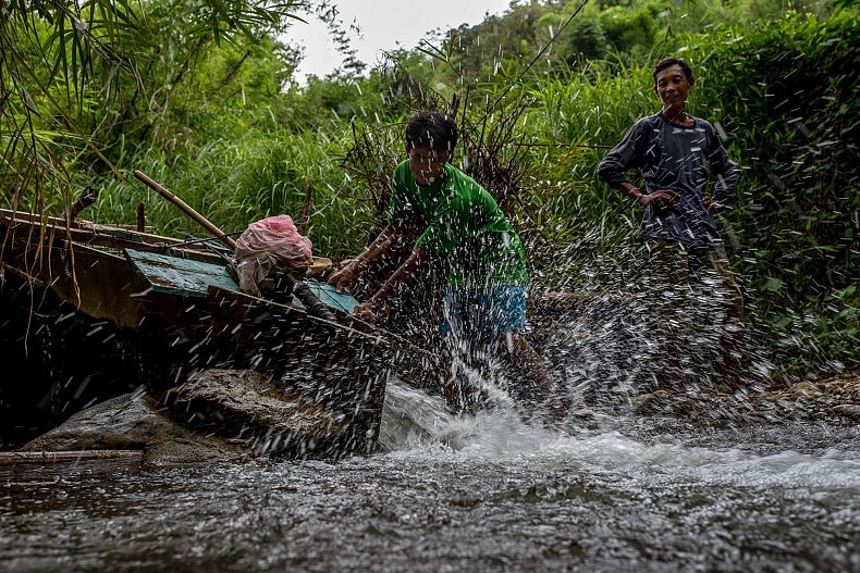 A man turns on his water turbine as evening approaches in the village of Khoc Kham. Photo by Luc Forsyth.