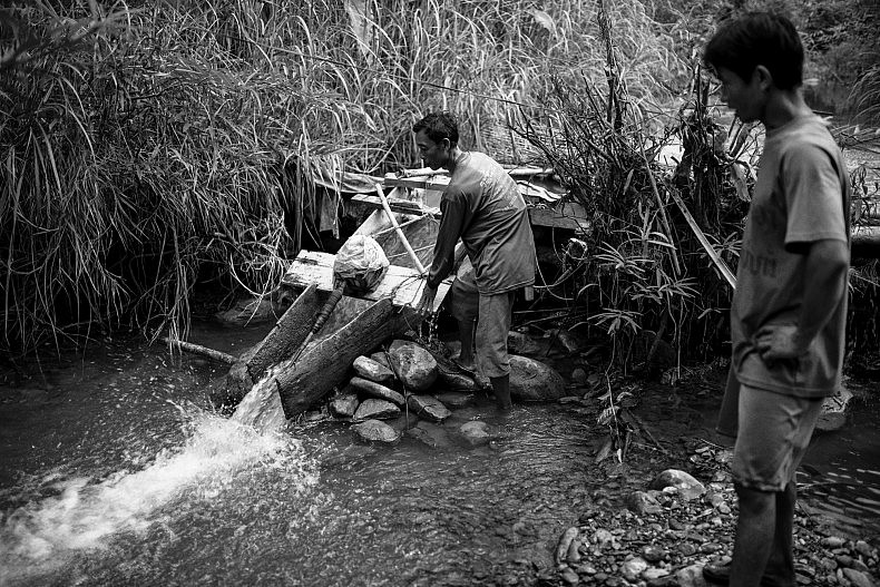 Men gather around the village's source of electricity. Photo by Gareth Bright.