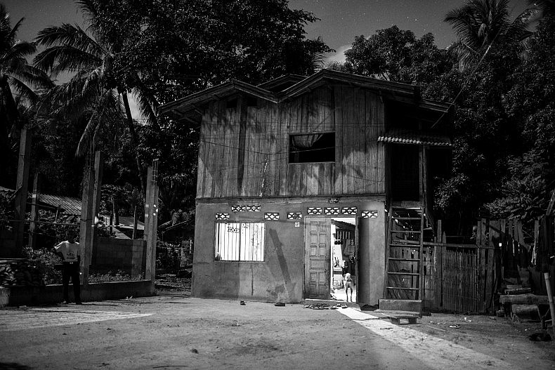 A light shines from inside a house in the village of Khoc Kham. Photo by Gareth Bright.