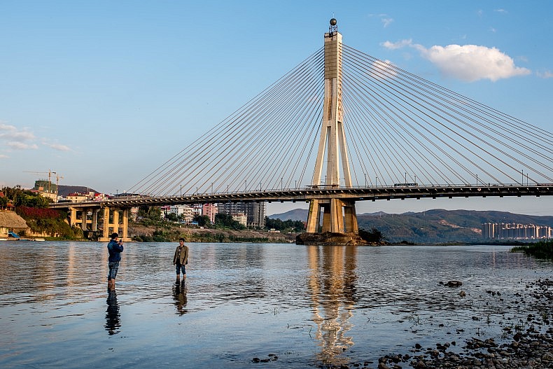 Tourists and locals gather along the Lancang (Mekong) river in Xishuangbanna, China.Photo by Luc Forsyth.