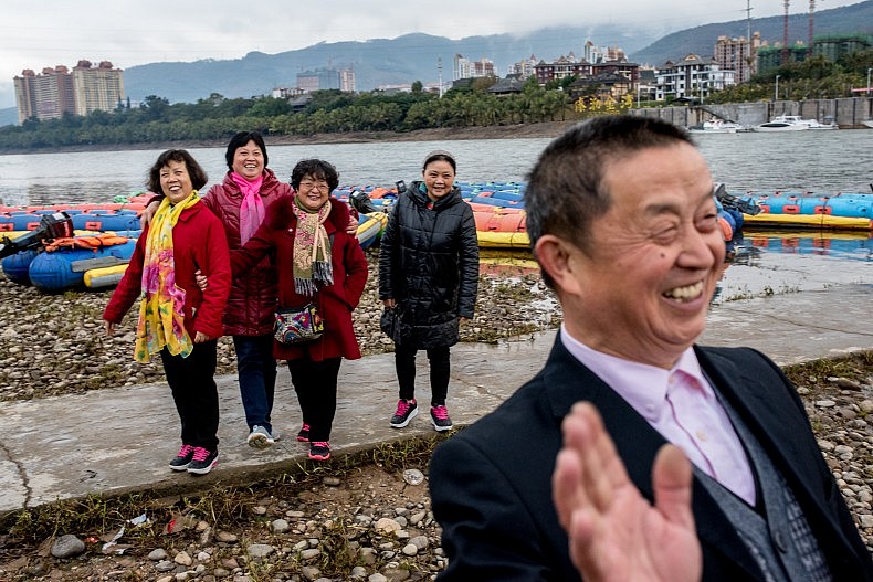 Tourists pose for pictures along the Lancang (Mekong) river in Xishuangbanna, Yunan, China. Photo by Luc Forsyth.