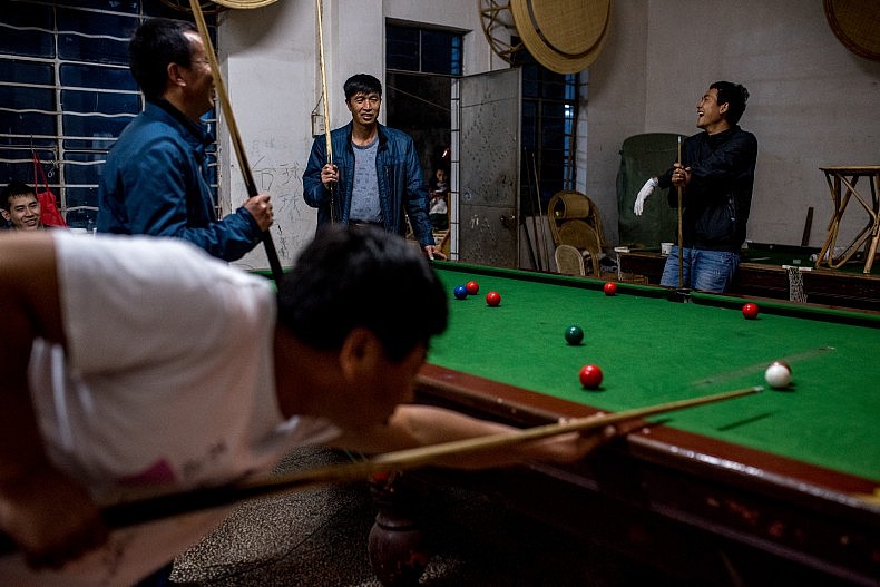 The crew of a sand dredging vessel relax by playing pool at the end of their workday. Photo by Luc Forsyth.