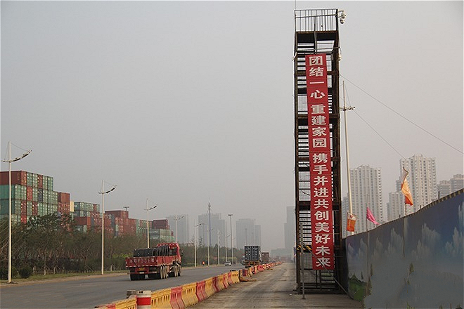 Slogan near the explosion site encourages people to rebuild their homes and create a better future. (Image by Wang Tao)