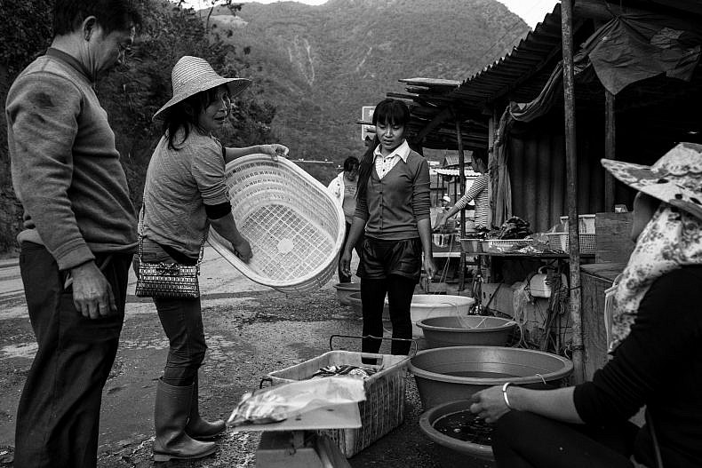 Customers stop at a road side fish market in Jinglin, Yunnan, China. Photo by Gareth Bright.