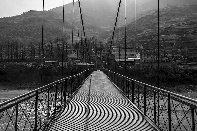Xialuoga is connected to the outside world only by a steel-cabled suspension bridge. Photo by Gareth Bright.