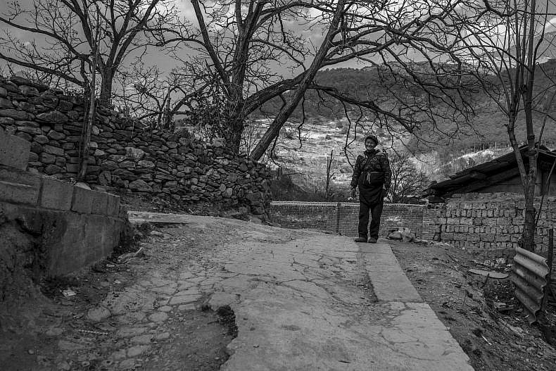 A man stands near his home in Xialuoga. Photo by Gareth Bright.