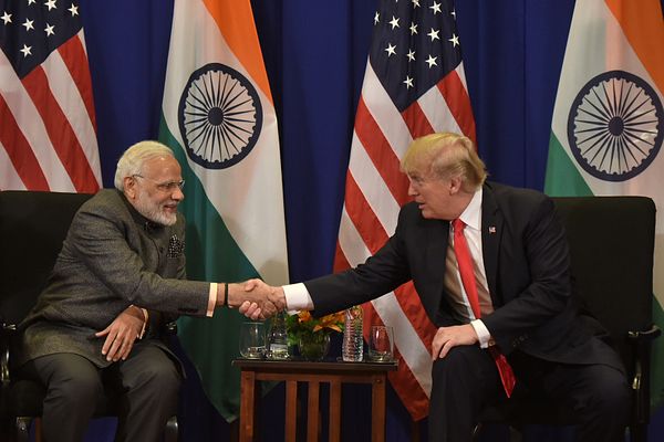 arafed image of two men shaking hands in front of flags